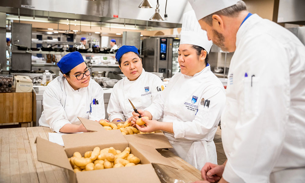 students peeling potatoes in nait kitchen