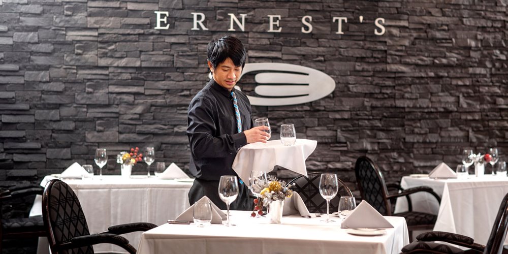 hospitality management student setting table at ernest's, nait's on-campus restaurant