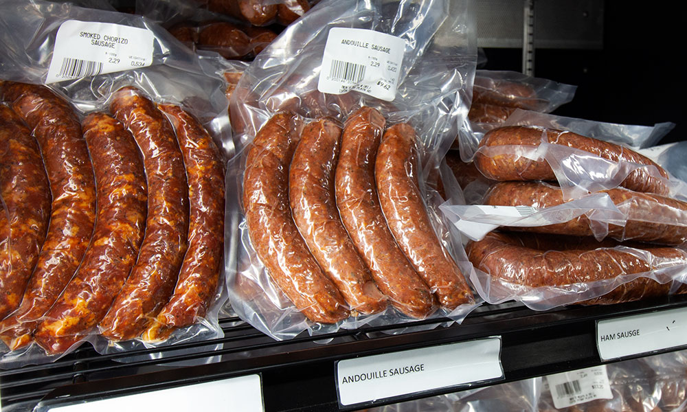 packages of sausage in a refrigerator on shelves