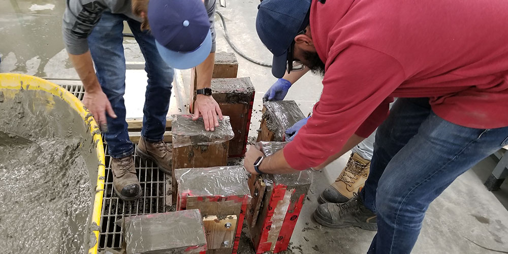 nait civil engineering students pouring concrete skis using wooden forms