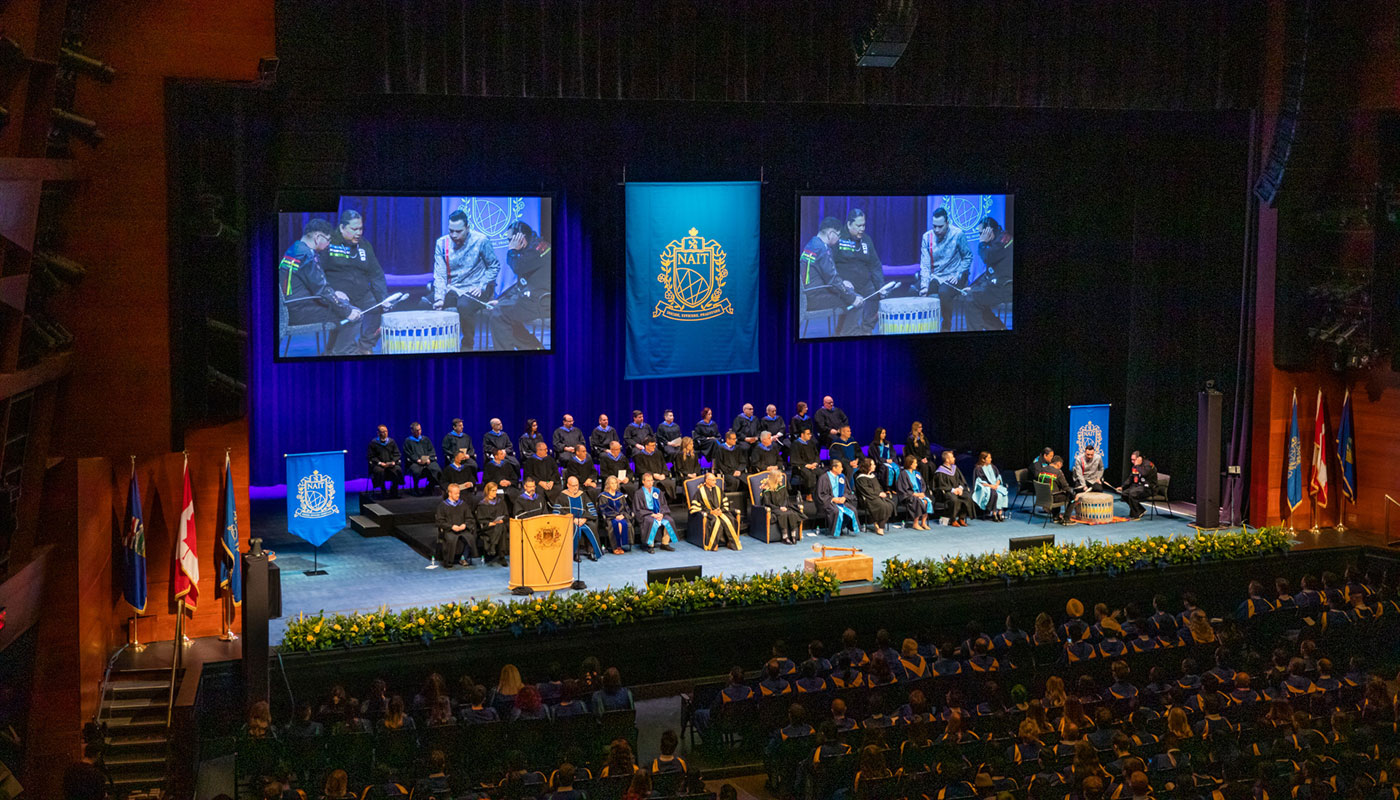 on screen, an honour song is performed at NAIT convocation 2022