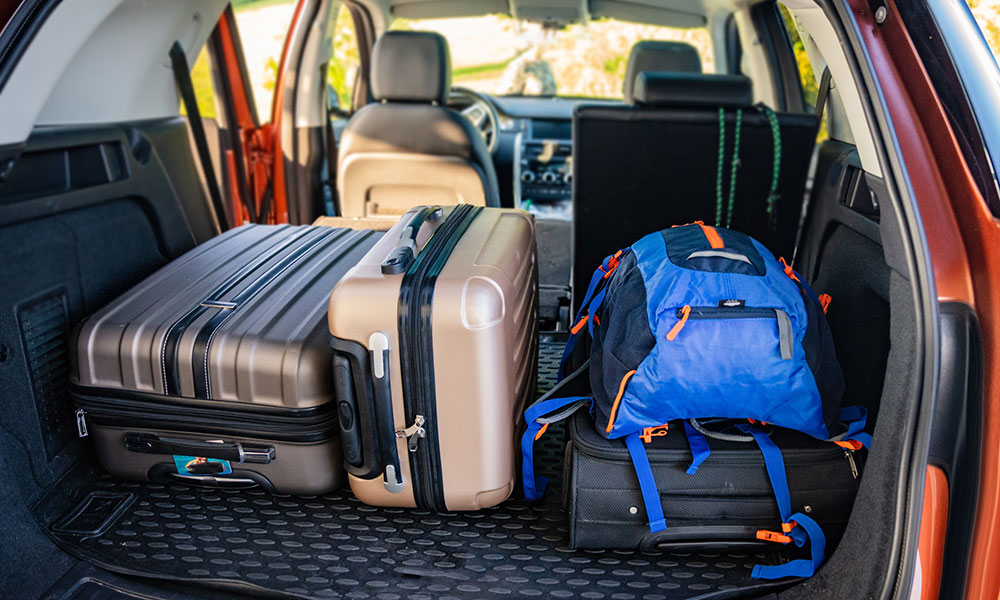 luggage packed in the back of an SUV with the hatch open