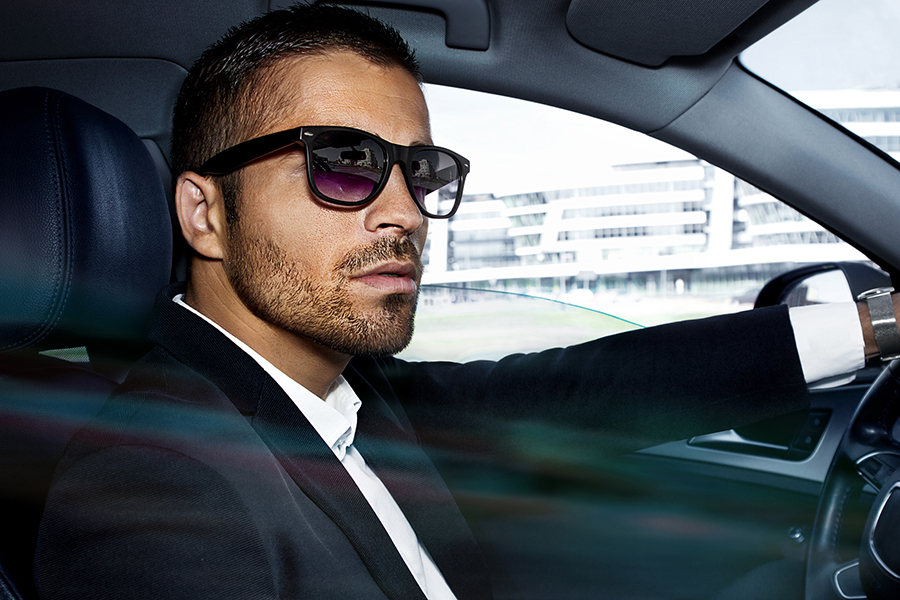 man in sunglasses driving a car