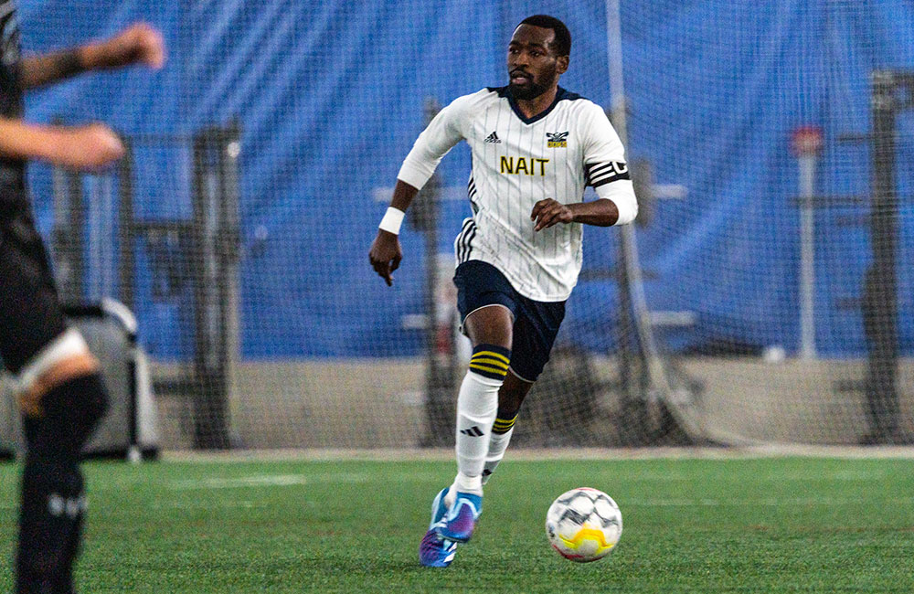 nait ooks men's soccer player carrying the ball