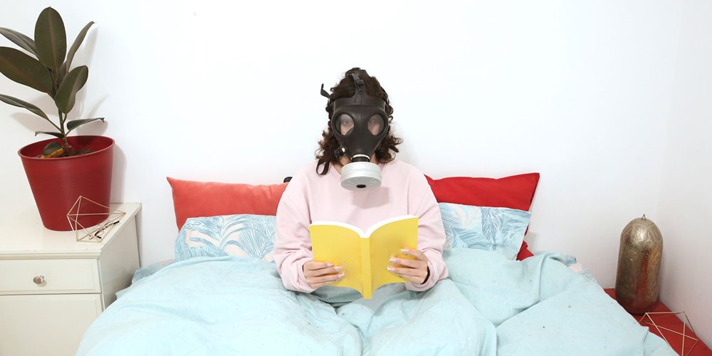 woman in bed wearing a gas mask
