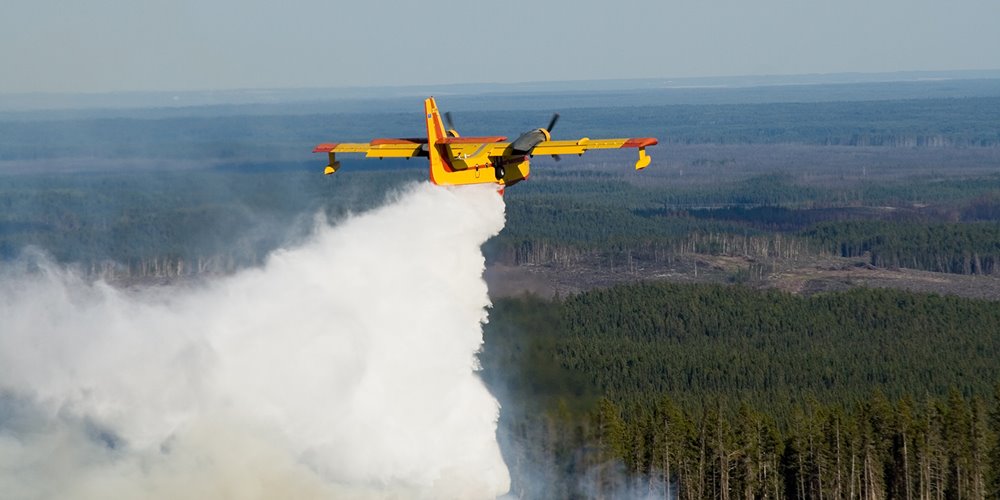 water bomber flying over wildfire